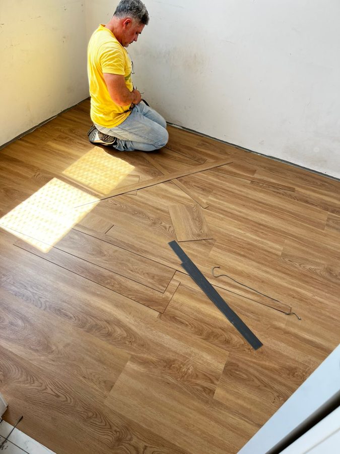 Instalador assentando as réguas de piso vinílico